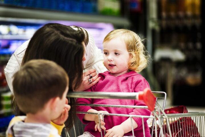 moeder met kleine kinderen in supermarkt